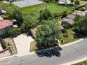 Aerial view of a single Gathering home with large driveway surrounded by mature trees and a green lawn at 3780 W 66Th Ave, Arvada, CO 80003
