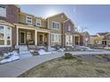 Attractive exterior view of two-story townhomes, featuring brick accents and a well-kept landscape at 6268 Pike Ct # D, Arvada, CO 80403