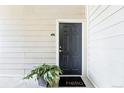 Inviting front door with modern black finish and stylish welcome mat surrounded by lush potted plants at 5763 N Gibralter Way # 2-108, Aurora, CO 80019