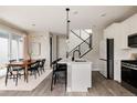 Modern open-concept kitchen featuring a white center island, stainless steel appliances, and a dining area at 10025 E 63Rd Ave, Denver, CO 80238