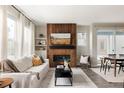 Bright living room with a striking wood accent wall, modern fireplace, and plenty of natural light at 10025 E 63Rd Ave, Denver, CO 80238