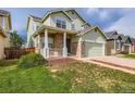 Charming two-story home featuring a brick-accented front porch and attached two-car garage with driveway at 20861 E 40Th Ave, Denver, CO 80249