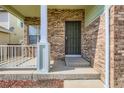 The cozy front porch has a metal security door and brick accents, and a welcoming entrance to the home at 20861 E 40Th Ave, Denver, CO 80249