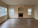 Bright living room featuring a decorative fireplace, large windows, and modern laminate flooring at 20861 E 40Th Ave, Denver, CO 80249