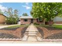 Charming brick home with manicured front yard and decorative landscaping elements at 11433 Carlile St, Northglenn, CO 80233