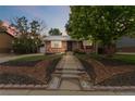 Charming brick home with manicured front yard and decorative landscaping elements at dusk at 11433 Carlile St, Northglenn, CO 80233