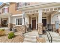 Charming front porch with stone accents and cozy seating area, perfect for relaxing outdoors at 871 E 98Th Ave # 1402, Thornton, CO 80229