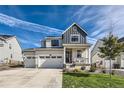 Two-story home with gray and white siding, three car garage, and front porch at 1173 Williams Loop, Elizabeth, CO 80107