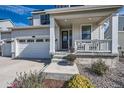 Front porch with rocking chairs, white columns, and tasteful flower pots at 1173 Williams Loop, Elizabeth, CO 80107