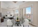 Living room with neutral tones and glass table with chairs, leading to a balcony with city views at 1827 N Grant St # 1104, Denver, CO 80203