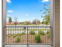 A cozy balcony with iron railings overlooking a landscaped yard and a vibrant cityscape at 981 S Sable Blvd # 107, Aurora, CO 80012