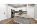 Bright kitchen boasts stainless steel appliances, granite countertops, and a functional center island at 981 S Sable Blvd # 107, Aurora, CO 80012