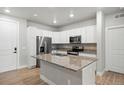 Contemporary kitchen features white cabinets, stainless steel appliances, and an island with granite countertop at 981 S Sable Blvd # 107, Aurora, CO 80012