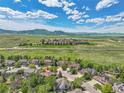 Scenic aerial view of a neighborhood with lush greenery, mountains in the distance and a tranquil lake at 1795 Eldorado Cir, Superior, CO 80027