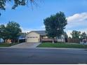 Charming single-Gathering home with a well-manicured lawn, mature trees, and a two-car garage at 808 Idalia St, Aurora, CO 80011