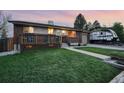 Well-maintained lawn and charming front porch with space for seating in front of brick home at 11398 W Ford Pl, Lakewood, CO 80226