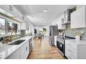 Modern kitchen features white cabinetry, stainless appliances, and mosaic backsplash at 16130 Mt Vernon Rd, Golden, CO 80401