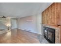 Spacious living area boasting a cozy fireplace with stone surround and wood paneling at 14780 E Kentucky Dr # 432, Aurora, CO 80012