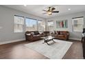 Bright living room with hardwood floors, stylish furnishings, and large windows offering plenty of natural light at 3980 Trail Stone Cir, Castle Rock, CO 80108