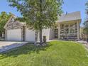 Inviting home with a well-manicured lawn and covered porch, complemented by stone and siding accents at 10904 Eagle Run Dr, Parker, CO 80138