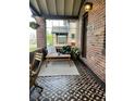 Charming screened-in porch with patterned floors and cozy seating arrangement at 2740 N Fillmore St, Denver, CO 80205