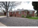 Brick home with a gravel front yard and mature landscaping, offering curb appeal at 5582 E Colorado Ave, Denver, CO 80222