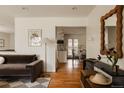 Cozy living room featuring hardwood floors and a seamless transition to the kitchen at 5700 E Floyd Ave, Denver, CO 80222