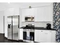 Bright kitchen with stainless steel appliances, white cabinets, and black countertops at 1402 Meade St, Denver, CO 80204