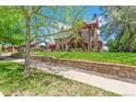 Beautiful exterior view of a stone house with lush landscaping and mature trees at 3520 Newton St, Denver, CO 80211