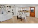 Bright kitchen featuring an island with white countertops and seating, stainless steel appliances, and light hardwood floors at 2290 E Columbia Pl, Denver, CO 80210