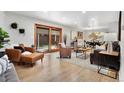 Bright living room featuring hardwood floors, stylish furniture, and sliding glass doors to the backyard at 2290 E Columbia Pl, Denver, CO 80210