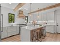 Modern kitchen with white cabinets, a large island, and wooden beams at 1655 S Marion, Denver, CO 80210