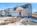 Two-story home with blue siding, red door, and a two-car garage at 3987 N Riviera Ct, Aurora, CO 80019