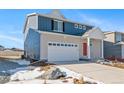 Two-story home with blue siding, red door, and a two-car garage at 3987 N Riviera Ct, Aurora, CO 80019