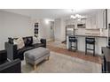 Bright open-plan living room with a breakfast bar and stainless steel appliances in the adjacent kitchen at 7040 E Girard Ave # 310, Denver, CO 80224