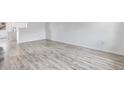 Spacious, minimalist living area with neutral tones, light wood flooring, and ample natural light at 12798 Ivy St, Thornton, CO 80602