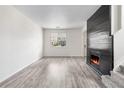 Cozy living room with a modern fireplace, large window, and neutral decor, creating a comfortable space at 12798 Ivy St, Thornton, CO 80602