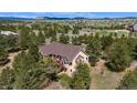 Rear aerial view of a single-Gathering home featuring a deck with views of a wooded area at 19050 Archers Dr, Monument, CO 80132