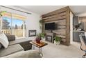 Inviting living room with a wood accent wall, fireplace, and access to the balcony at 3035 Oneal Pkwy # 36T, Boulder, CO 80301