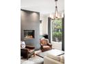 Inviting living room featuring a contemporary fireplace, leather seating, and large window overlooking the outdoors at 628 Cherry St, Denver, CO 80220