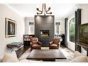 Stylish living room with modern fireplace, leather chairs, and large windows providing natural light and outdoor views at 628 Cherry St, Denver, CO 80220