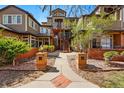 Inviting condo exterior with brick accents, mature landscaping and exterior wooden stairs at 6001 S Yosemite St # B207, Greenwood Village, CO 80111