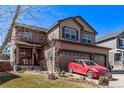 Two-story home featuring a two-car garage, neutral siding, well-kept landscaping, and covered entry at 7514 Blue Water Dr, Castle Rock, CO 80108