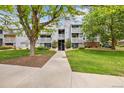 Well-maintained apartment building with lush landscaping and inviting walkway at 7665 E Eastman Ave # 110, Denver, CO 80231