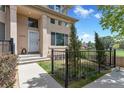 Attractive townhome front entrance featuring manicured lawn, black fence, and well-maintained landscaping at 14058 E Temple Dr, Aurora, CO 80015