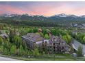 Scenic aerial view showcases property amidst lush greenery and snow-capped mountains at 33 Broken Lance Dr # 207S, Breckenridge, CO 80424