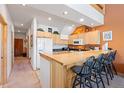 Well-equipped kitchen with wooden cabinets, breakfast bar seating, and modern appliances at 33 Broken Lance Dr # 207S, Breckenridge, CO 80424