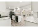 Spacious kitchen featuring modern appliances, marble countertops, an open floor plan, and a beautiful living room at 180 W 78Th Pl, Denver, CO 80221
