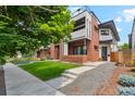 Stylish two-story residence featuring red brick accents, a well-maintained lawn, and a charming front terrace at 2244 S Lincoln St, Denver, CO 80210