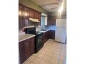 Cozy kitchen with dark wood cabinets, black appliances, and tile flooring at 606 Tennyson St, Denver, CO 80204